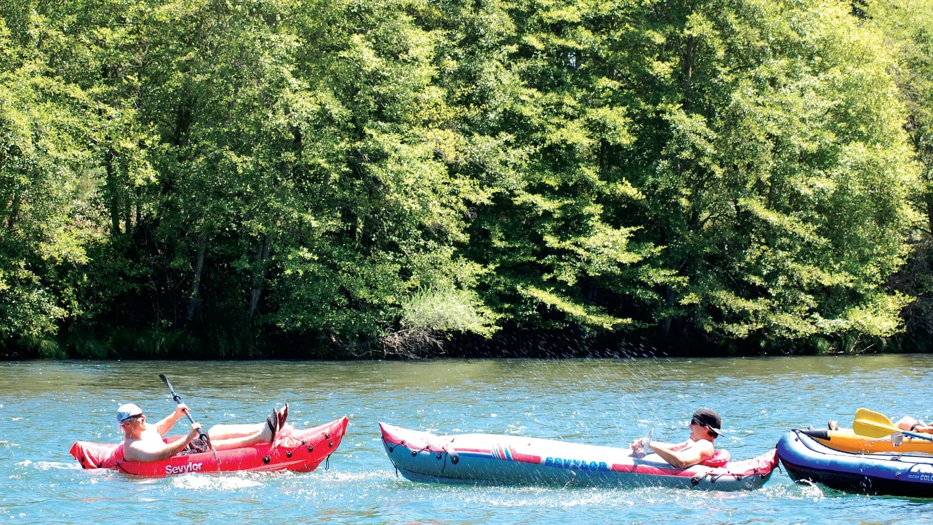 Three kayakers in the river.
