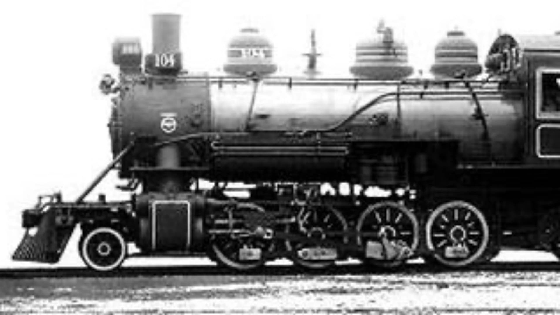 Side view of a vintage steam locomotive, featuring large wheels and a prominent smokestack.