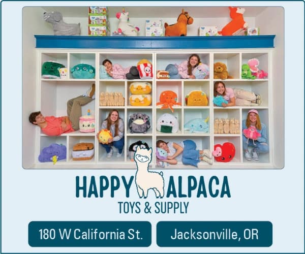 “Happy Alpaca Toys & Supply” ad with children posing in a shelf display and “180 W California St.” and “Jacksonville, OR” text
