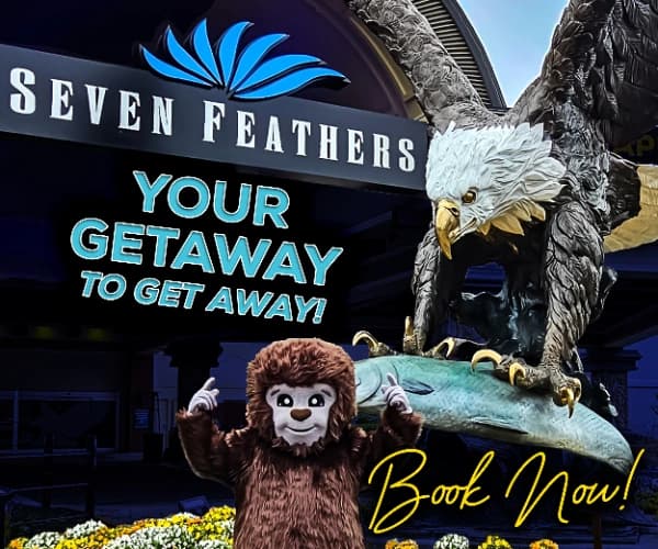 “Seven Feathers” sign with “YOUR GETAWAY TO GET AWAY” text; lion and eagle statues, “Book Now!” in yellow.